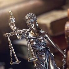 Justitia-Figur vor Büchern