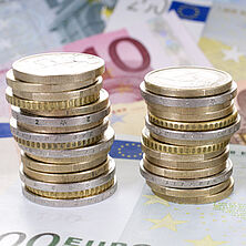 Euromünzen | Bildquelle: grafikplusfoto, Fotolia zu Türmen gestapelte Euromünzen, darunter Euroscheine