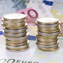 Euromünzen | Bildquelle: grafikplusfoto, Fotolia zu Türmen gestapelte Euromünzen, darunter Euroscheine